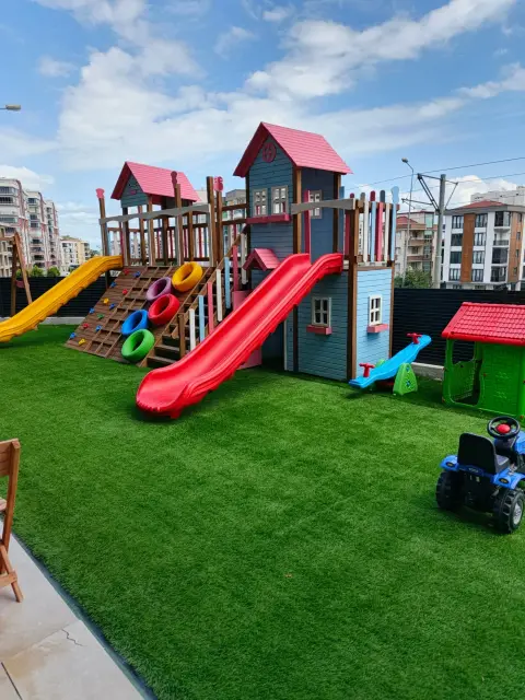 Bahçedeki ahşap oyun parkı ve kaydıraklar