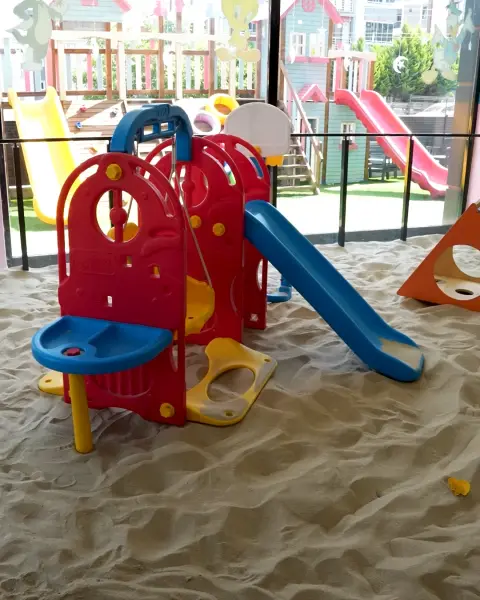 İç mekândaki kum havuzumuz ve bahçedeki oyun evlerinin manzarası